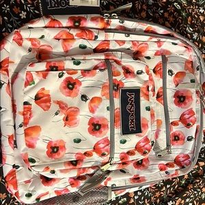 The brand is jansport, it’s a flower print bookbag